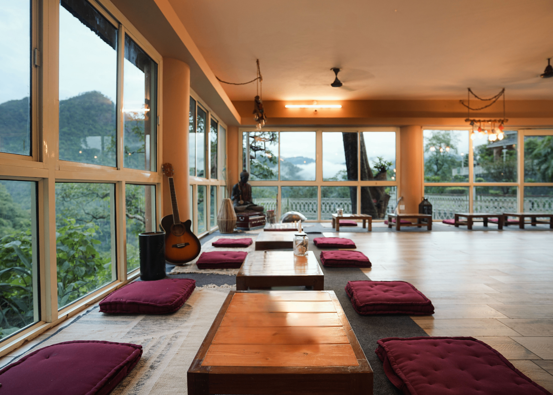 Bright open Rishikesh room with mountain view and meditation cushions